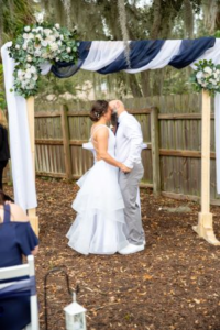 Bride and groom under archway in backyard wedding